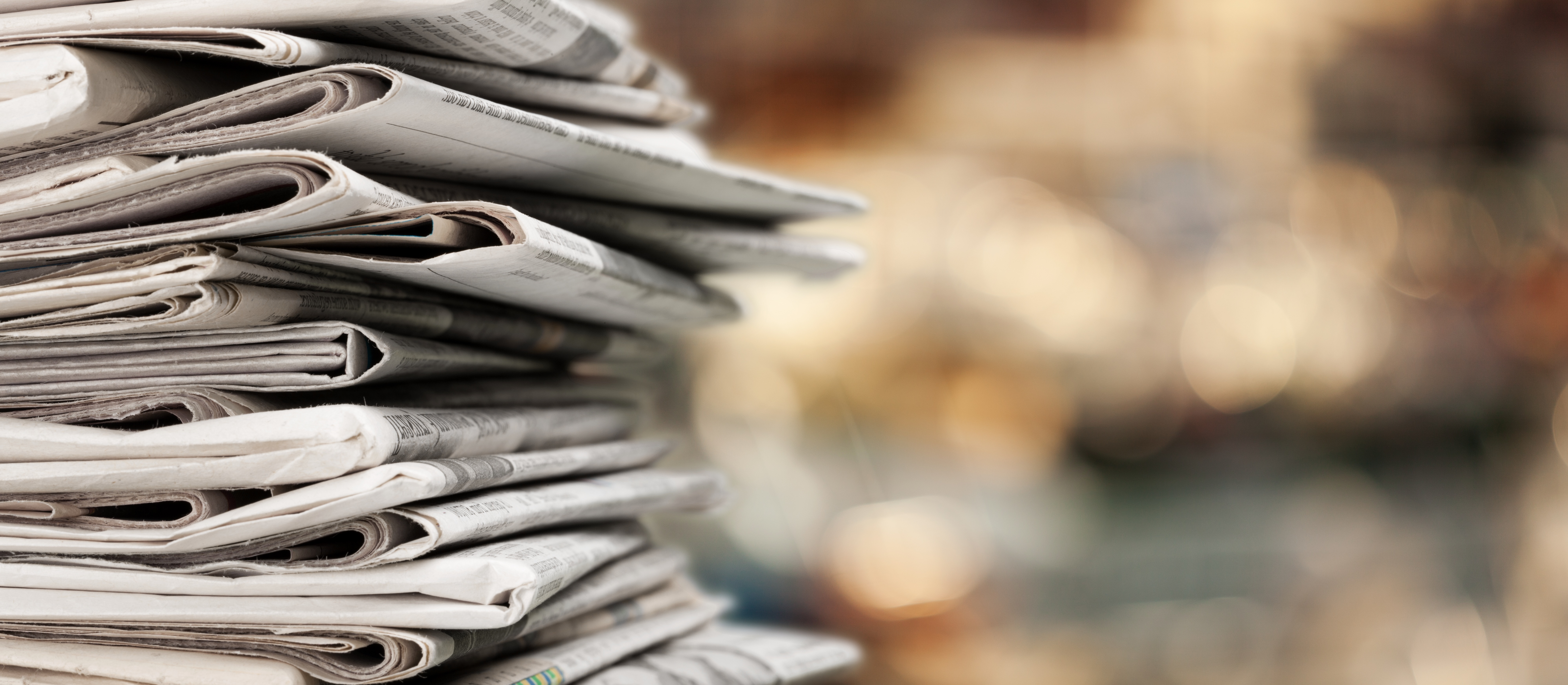 1771404605_pile-newspapers-stacks-blur-background-1.jpg